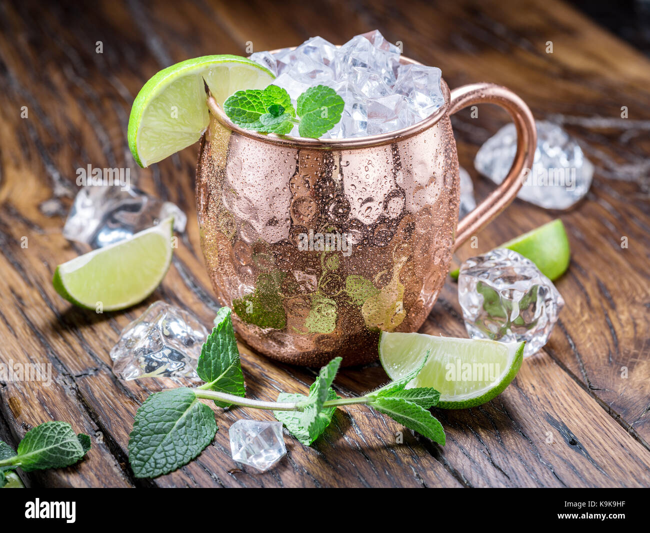 Moscow mule. frosty mug in rame con calce e cubetti di ghiaccio sul tavolo di legno. Foto Stock
