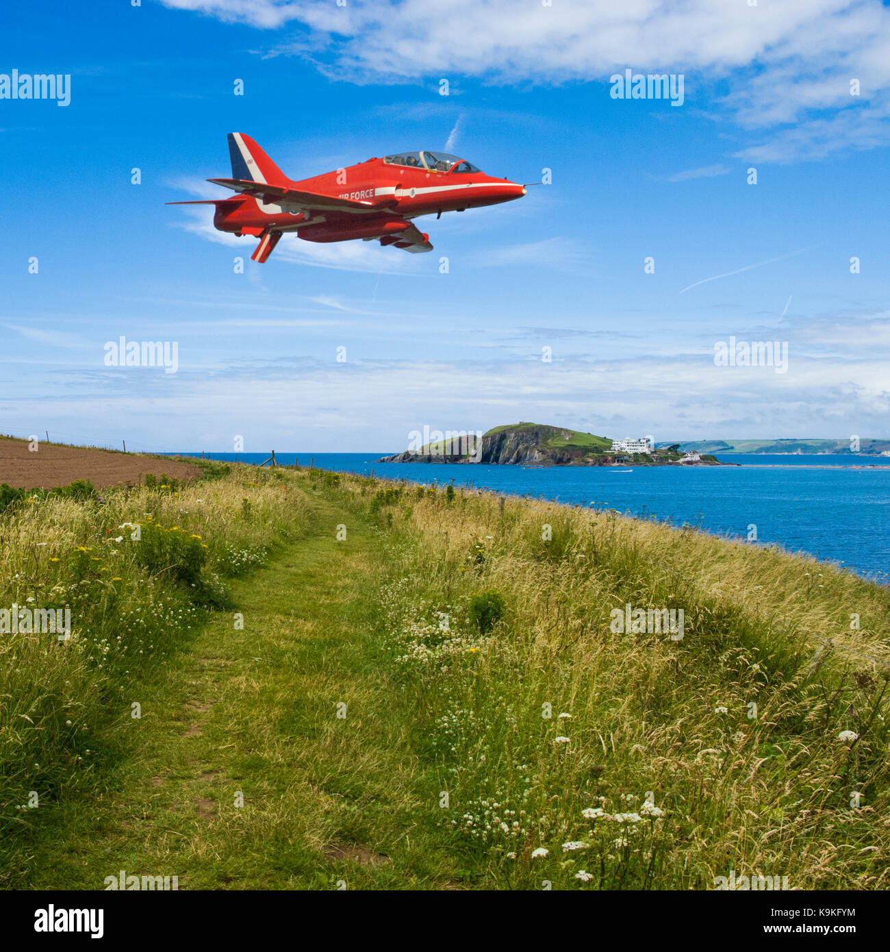 Composito della singola frecce rosse aerobatic team hawk volando a bassa quota sopra la bantham nel devon con burgh isola sullo sfondo di una soleggiata giornata estiva. Foto Stock