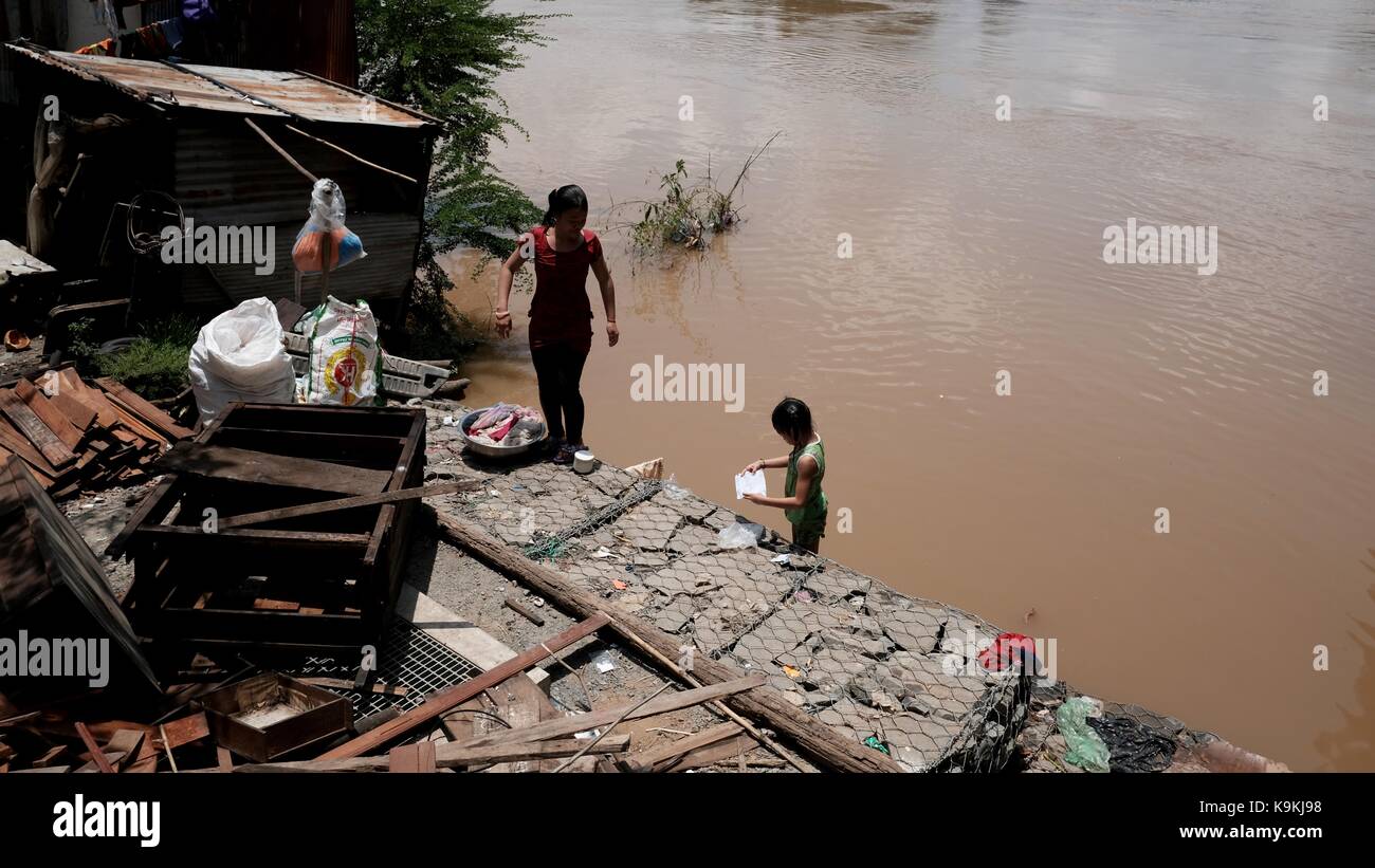 Phnom Penh Cambogia Monivong Bridge Bassac River Slum Area bambini sulla riva del fiume Foto Stock