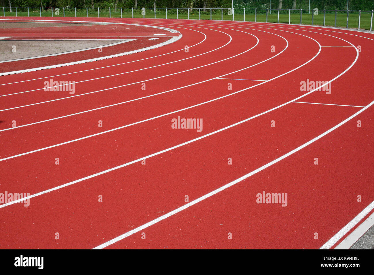 Piegare di un vuoto che la pista di atletica in un ambiente di verde Foto Stock