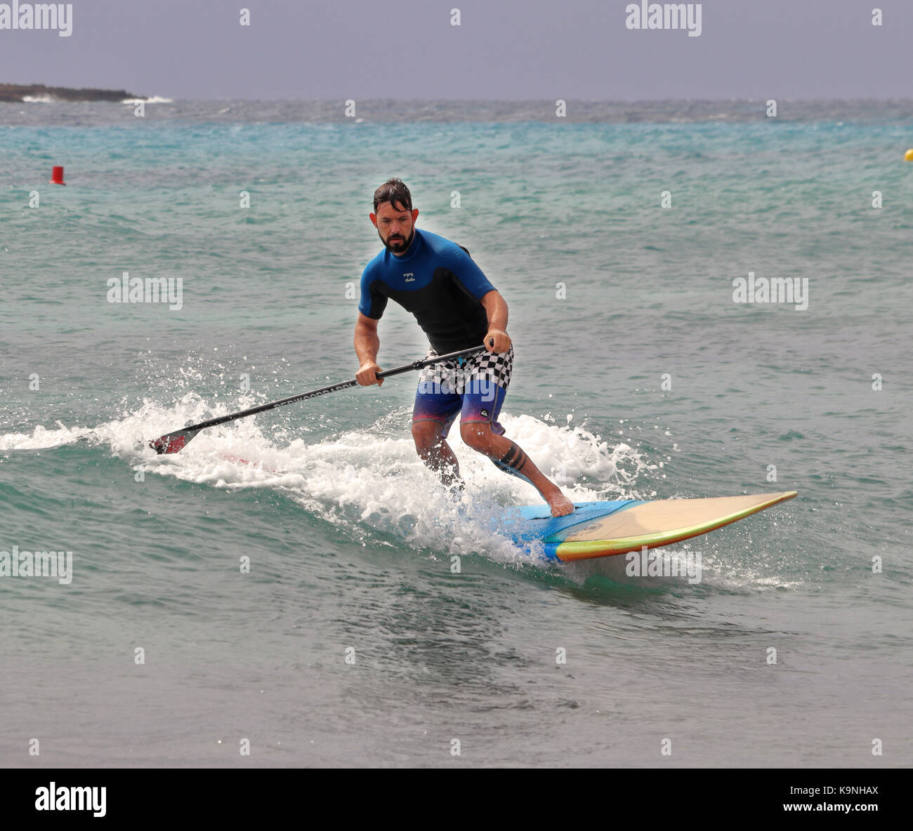I minorchini resort di punta prima nel mar mediterraneo con maschio scheda paddle surf Foto Stock