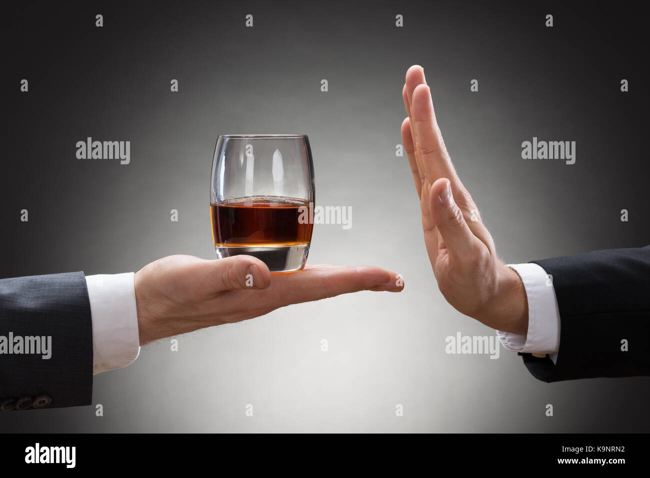 Close-up di imprenditore canto rifiutare un bicchiere di whisky offerto dai commercianti Foto Stock