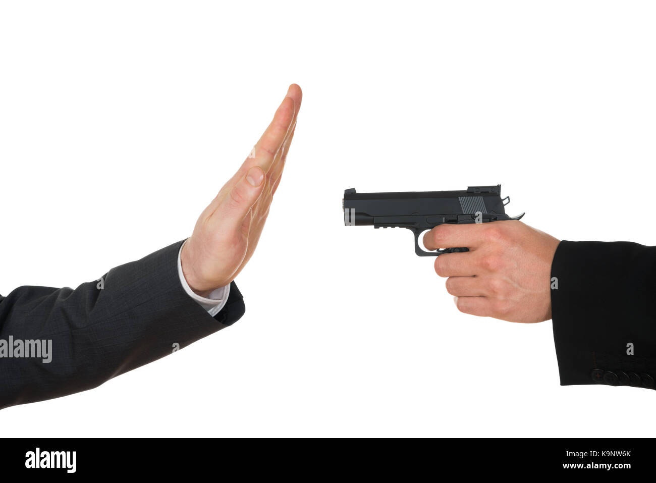 Imprenditore mano con la pistola rivolta verso i mediatori gesticolando stop su sfondo bianco Foto Stock