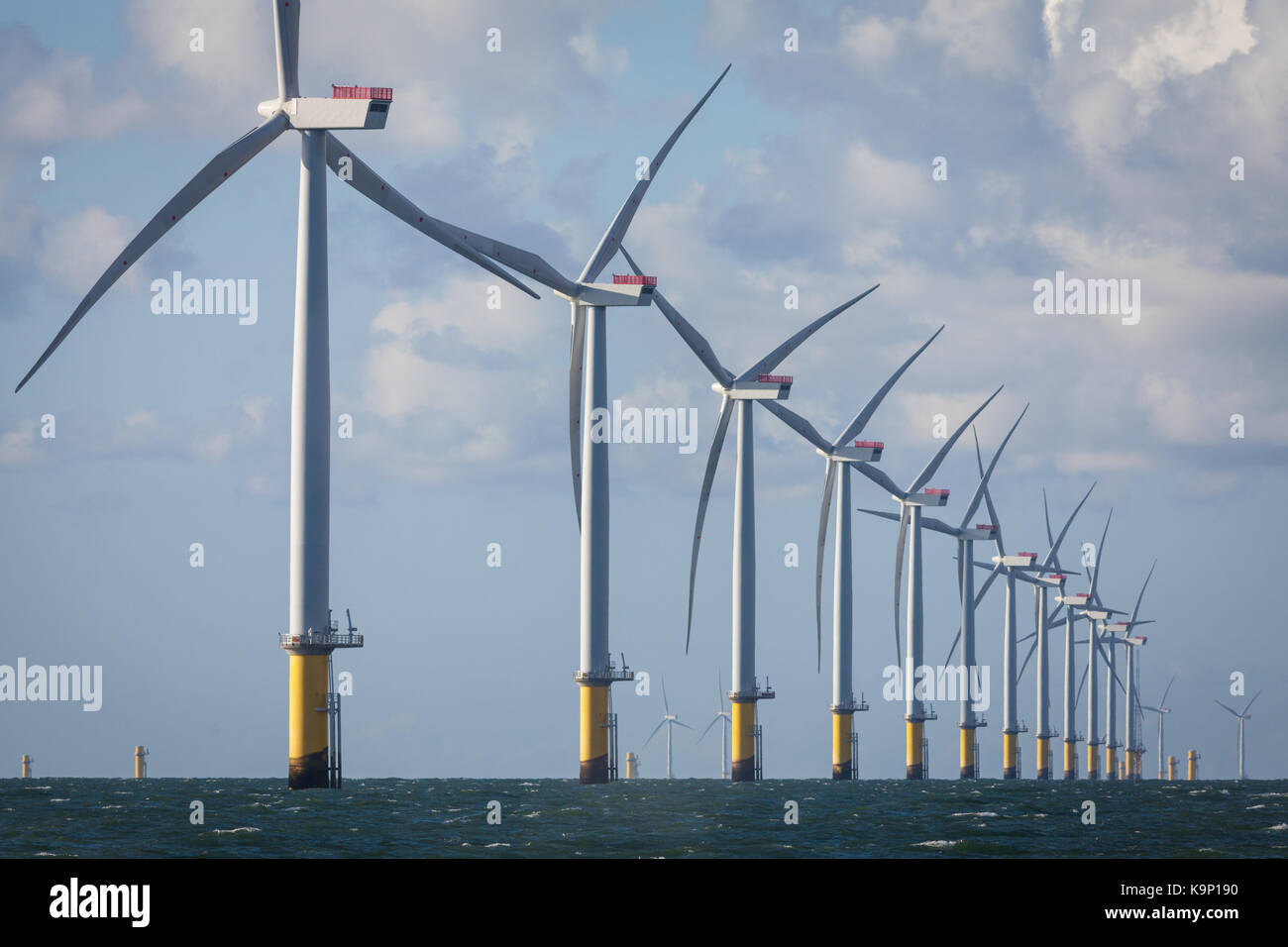 Turbine di West di Duddon Sands Offshore Wind Farm nel Mare d'Irlanda. Pezzi di transizione per il Walney estensione può essere visto in lontananza. Foto Stock