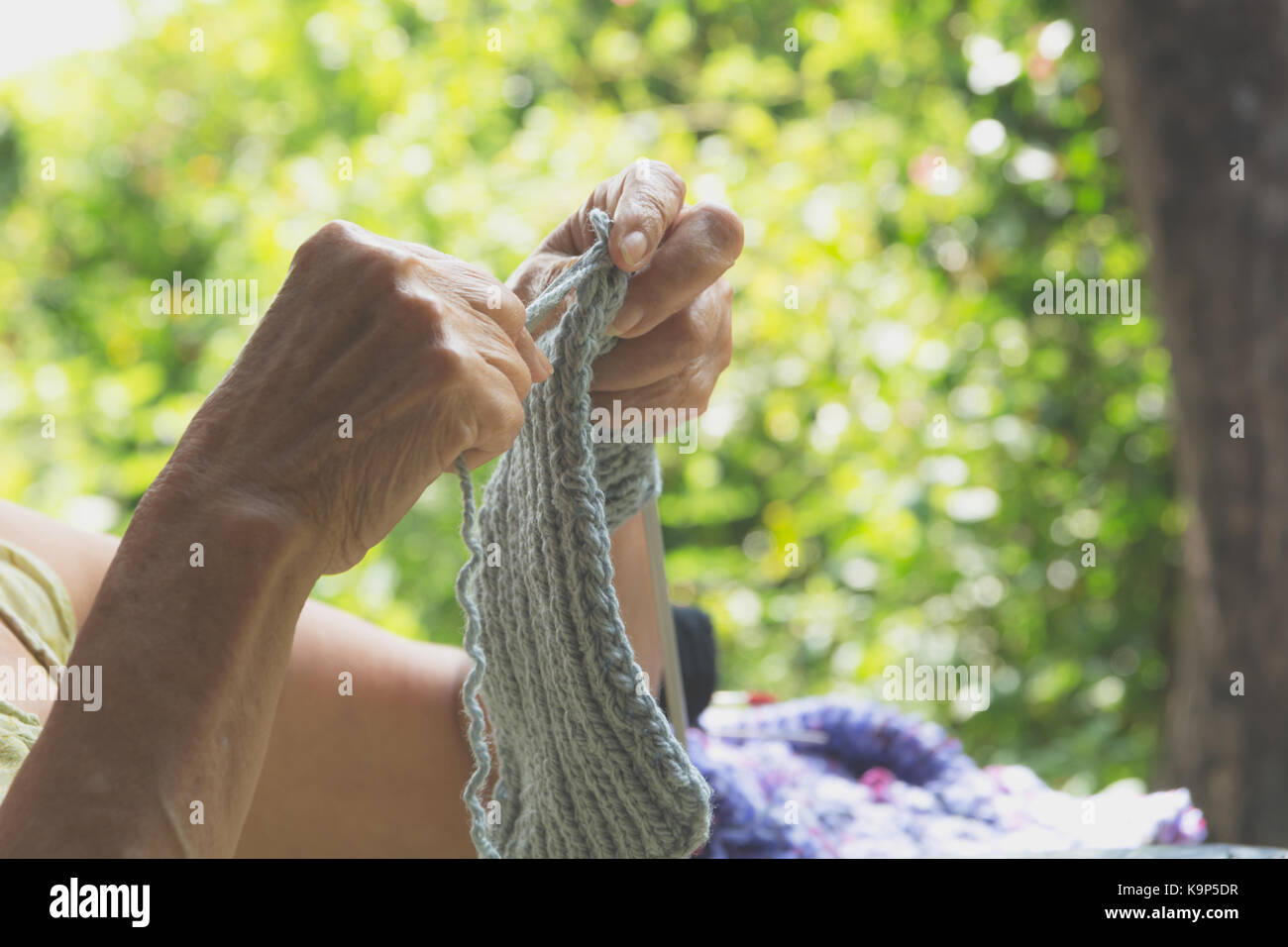 Il vecchio donna maglieria panni di lana. close-up di mani maglia. aghi di tessitura. Foto Stock