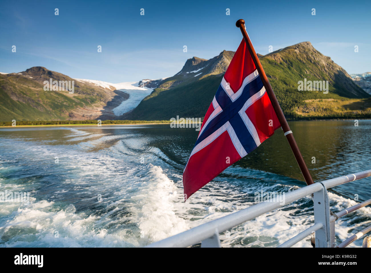 Norways bandiera sul traghetto arhaugfjorden trogolo per il ghiacciaio svartisen, holandsfjord, Norvegia, Scandinavia, Europa. Foto Stock