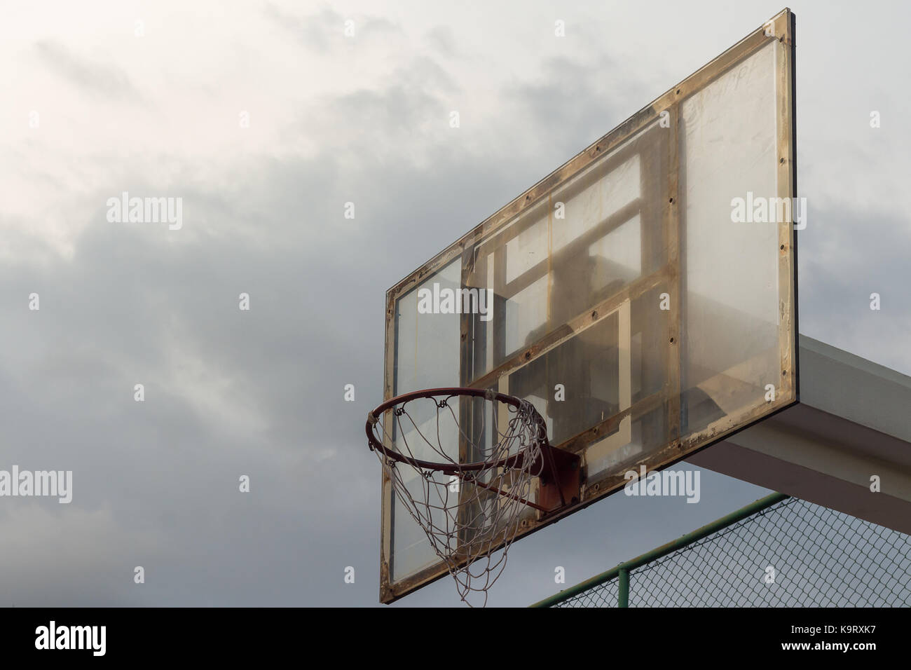 Lavagna basket contro il cielo tempestoso di sfondo e un piccolo raggio di sole per l'hoop(tema scuro) Foto Stock