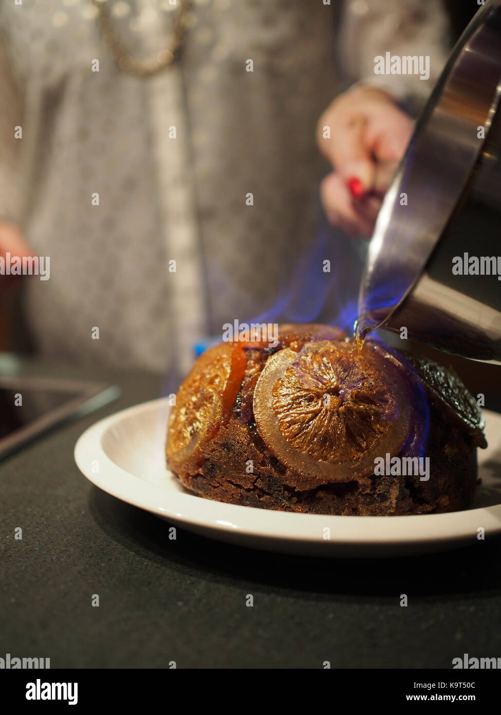 Il brandy con fiamma blu versata su un hot pudding natalizio Foto Stock