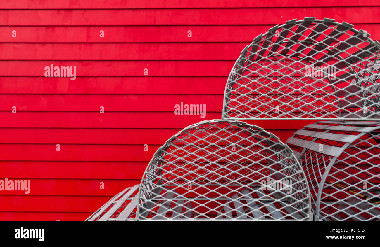 Un display di aragosta decorativo trappole sit contro una parete rossa di un edificio di Lunenburg. Fondata nel 1753 Lunenburg, Nova Scotia, Canada. Foto Stock