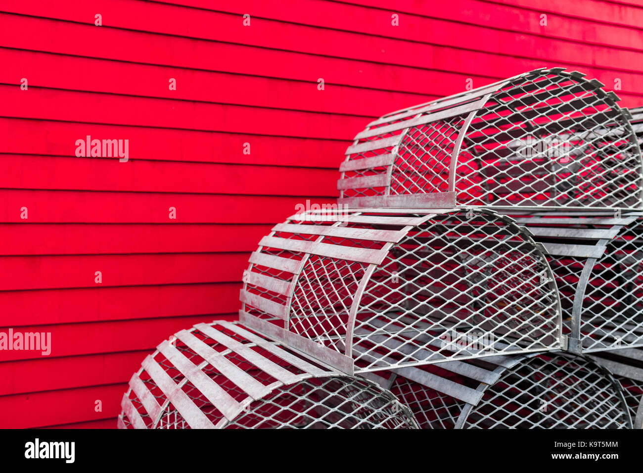 Un display di aragosta decorativo trappole sit contro una parete rossa di un edificio di Lunenburg. Fondata nel 1753 Lunenburg, Nova Scotia, Canada. Foto Stock