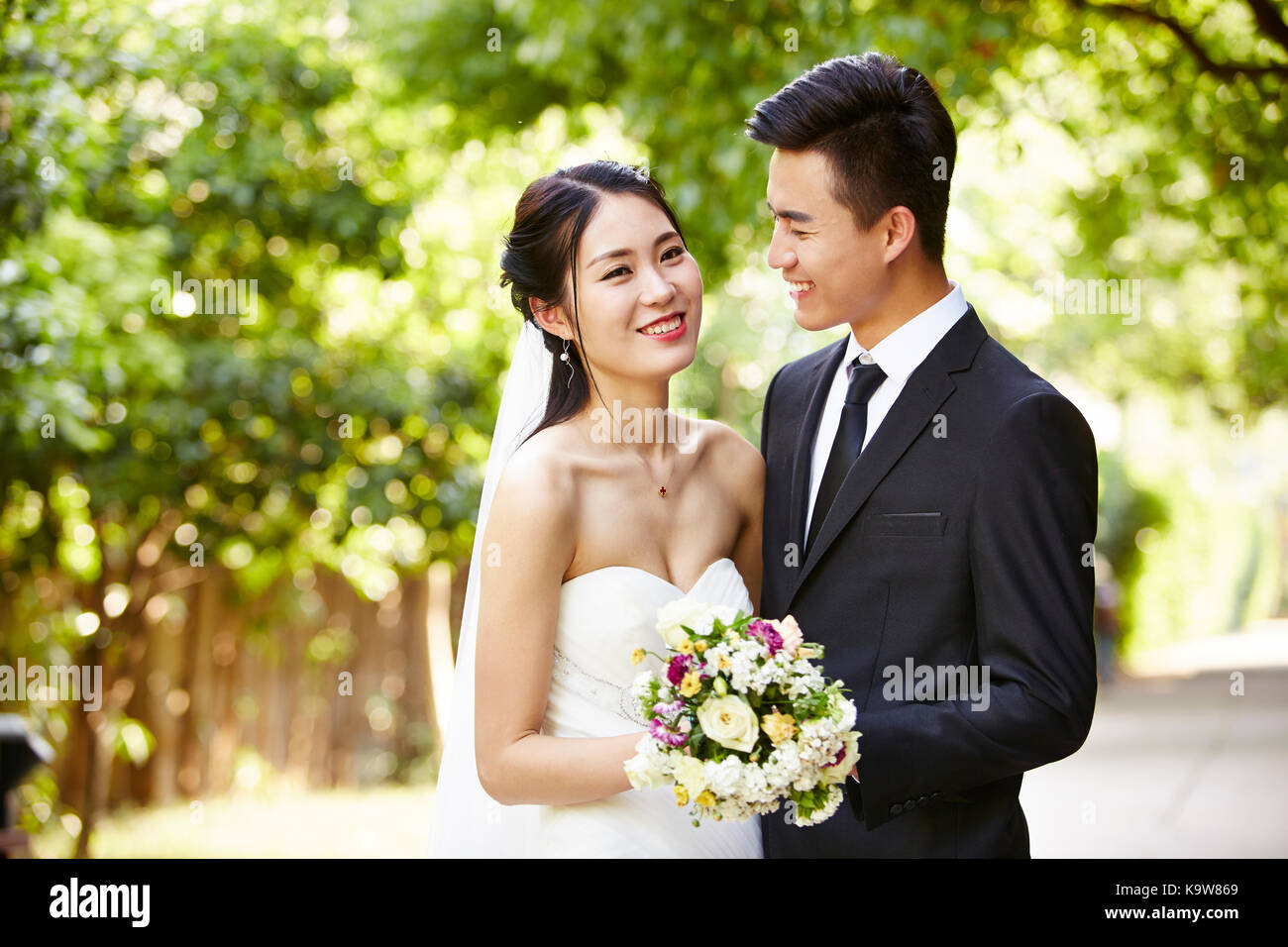 Outdoor ritratto di asian sposa e lo sposo, felice e sorridente. Foto Stock