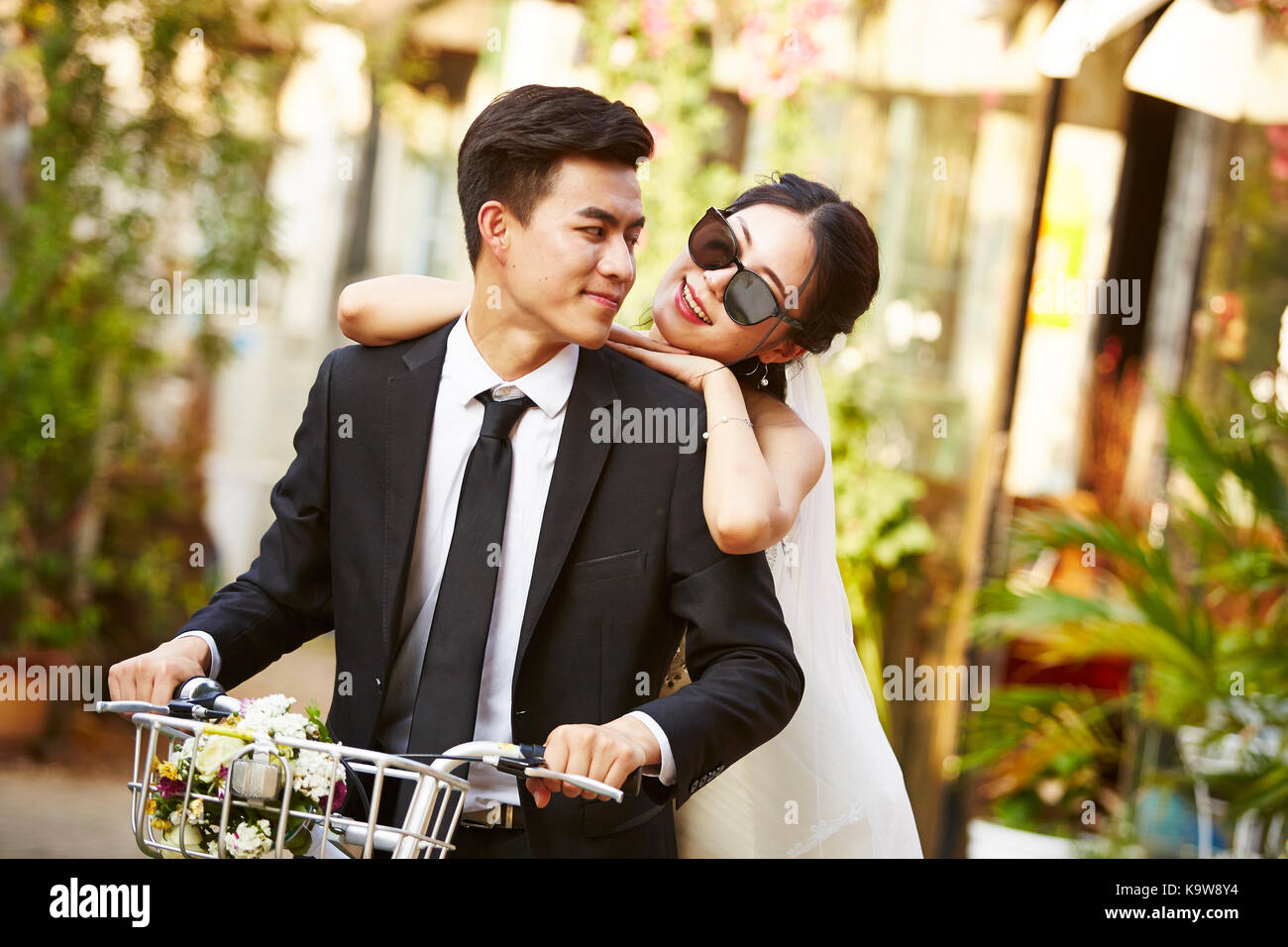 Happy sposi asian giovane divertirsi in sella ad una bicicletta. Foto Stock