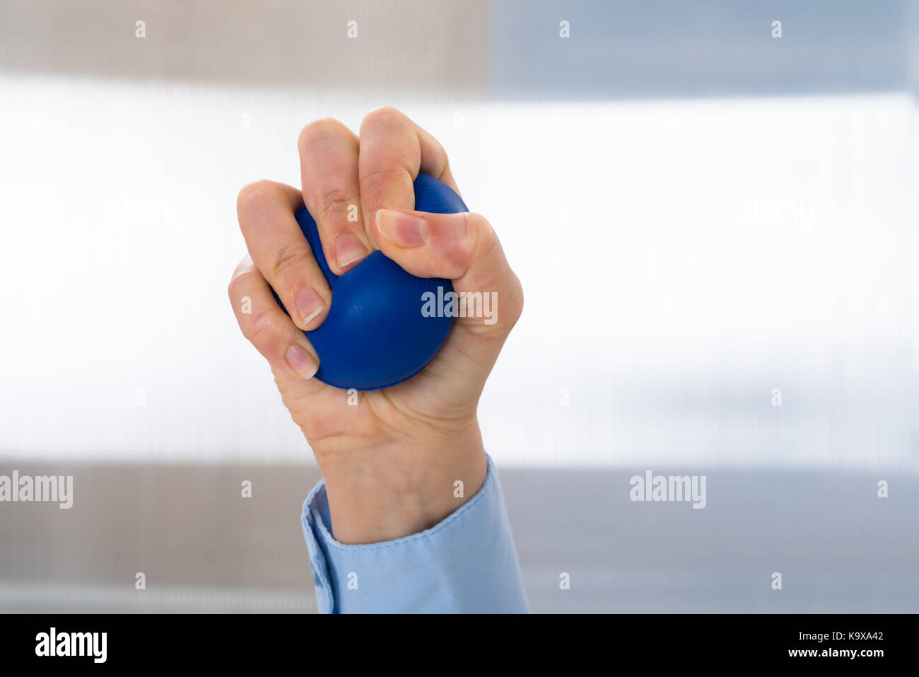Close-up di persona a mano azienda stressball blu Foto Stock