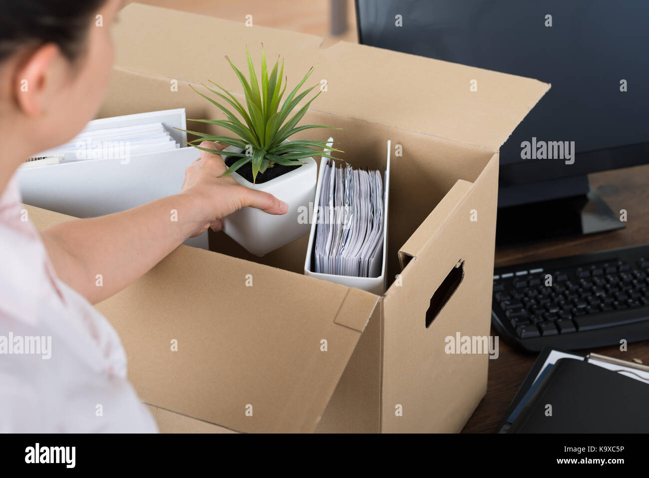 Giovane imprenditrice beni di imballaggio in cartone alla scrivania Foto Stock