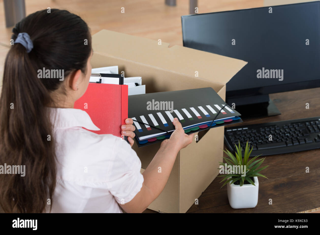 Giovane imprenditrice beni di imballaggio in cartone alla scrivania Foto Stock