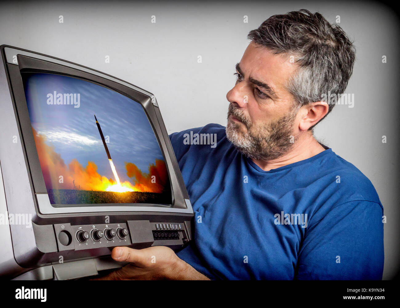L'uomo guarda la televisione vecchia notizie lancio del missile nella terza guerra mondiale Foto Stock