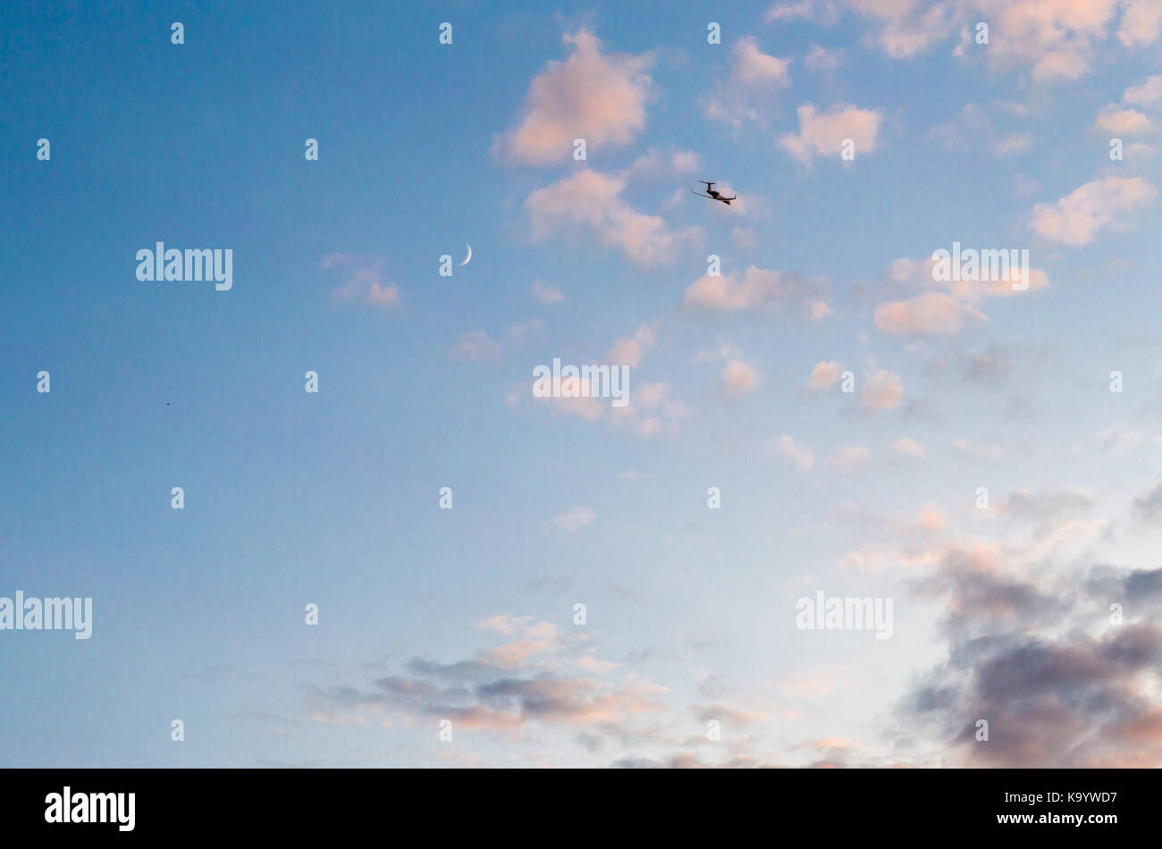 Piccolo aereo privato volare alto in un giorno di ritardo sky con nastro di luna visibile, Southampton, NY Foto Stock