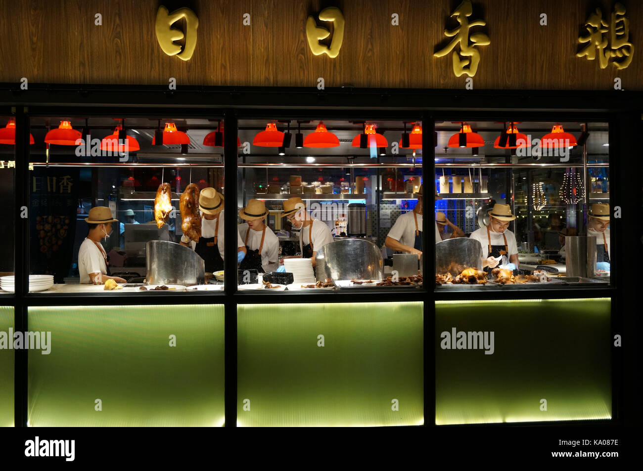 Il ristorante cinese lavoratori visto dietro una finestra di trinciatura anatre arrosto in shenzhen, Cina Foto Stock