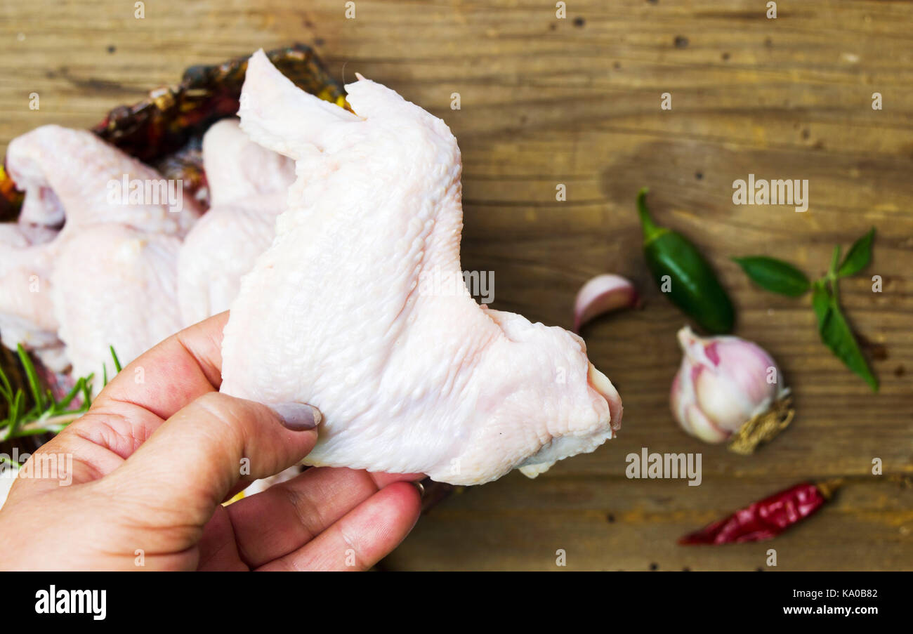 Mano che tiene il pollo crudo ala close up Foto Stock Mano che tiene il pollo crudo ala close up Foto Stock
