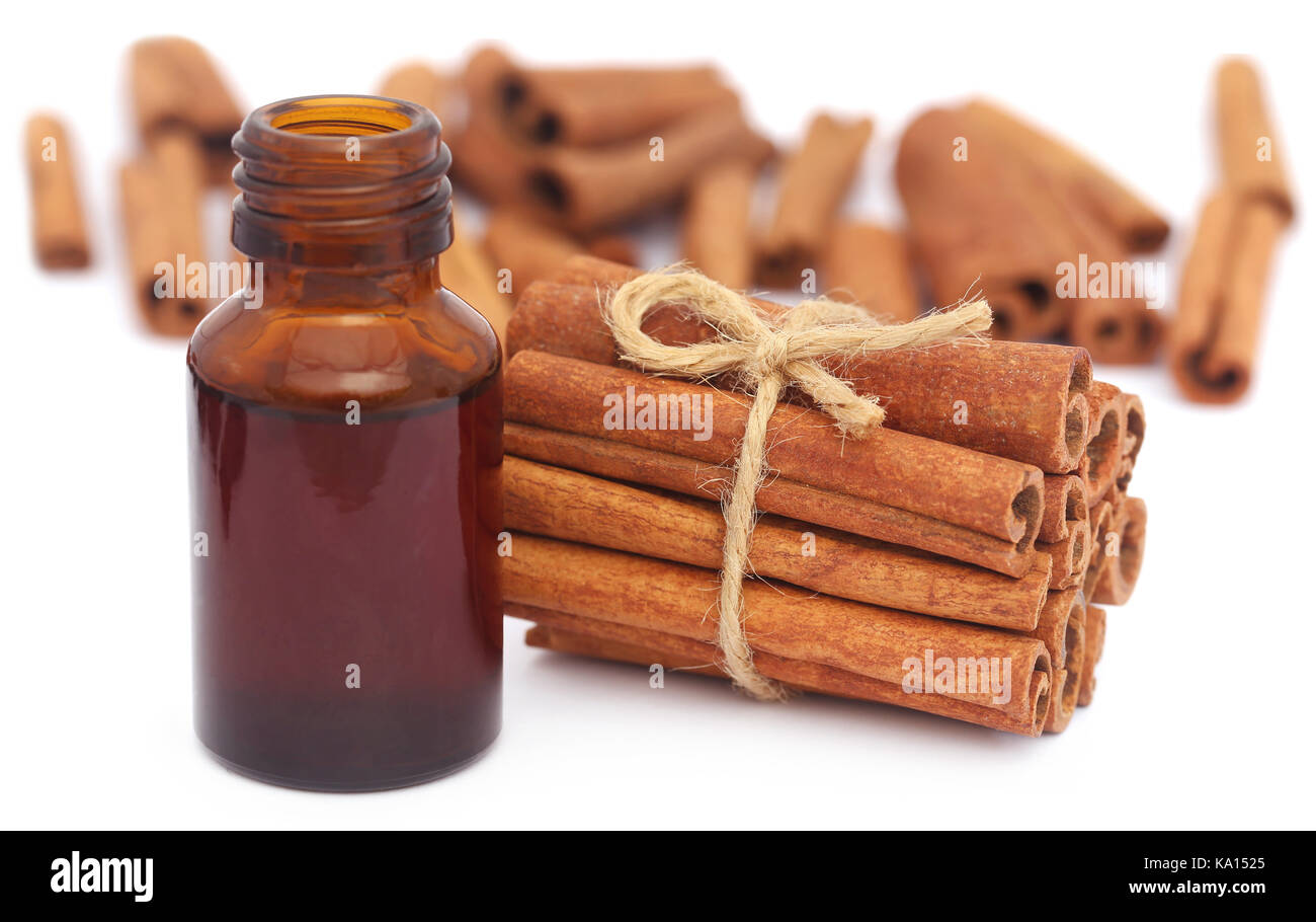 Mazzetto di alcuni freschi cannella aromatica con olio essenziale in una bottiglia Foto Stock