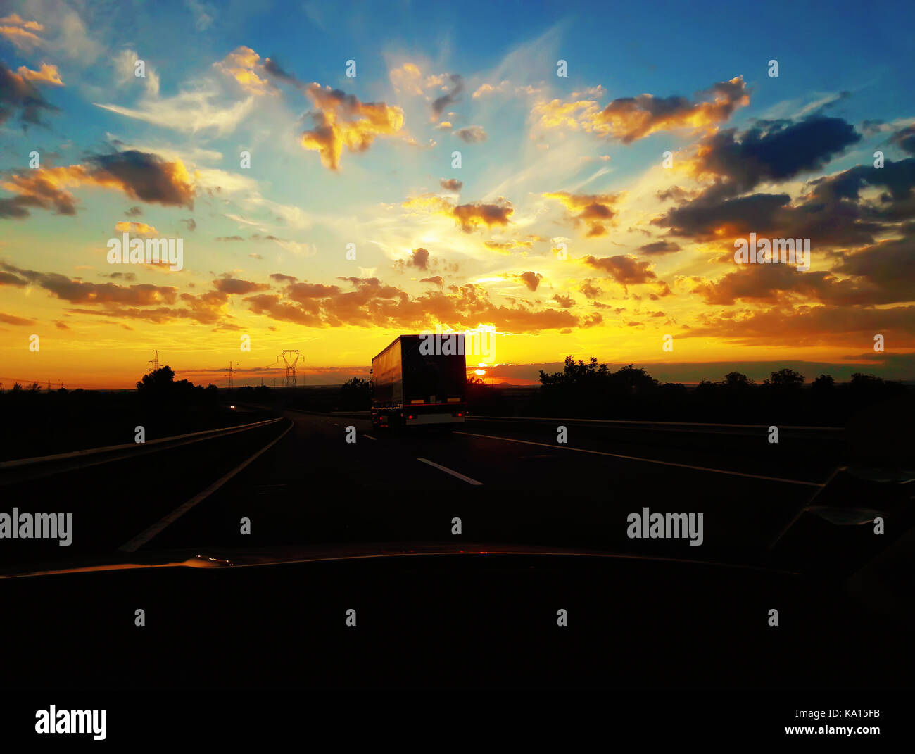 La guida su una strada dietro un camion su un bellissimo tramonto sfondo. viaggi in automobile, viaggio di vacanza. Foto Stock
