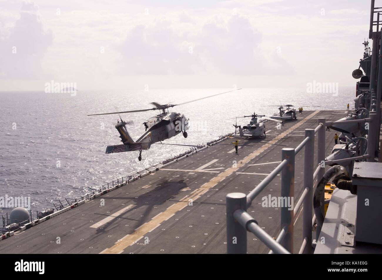 Un U.S. Navy MH-60S Knighthawk elicottero elicottero con mare squadrone di combattimento 26 trasporta il personale e le attrezzature fuori l'assalto anfibio della nave Foto Stock
