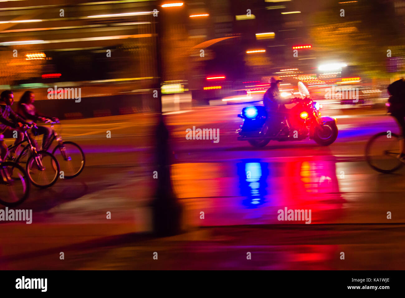 Polizia moto accompagnatrici di una massa di bicicletta in San Francisco di notte lungo Embarcadero. Foto Stock