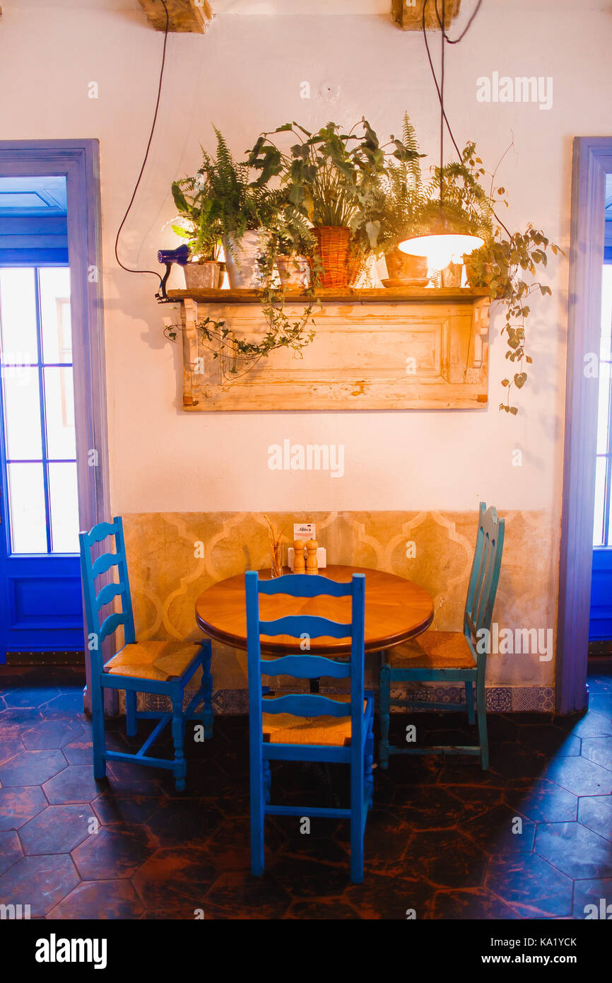 La foto in orizzontale dell'arredamento blu in piedi sotto il ripiano con vasi di fiori nel vintage cafe. Foto Stock