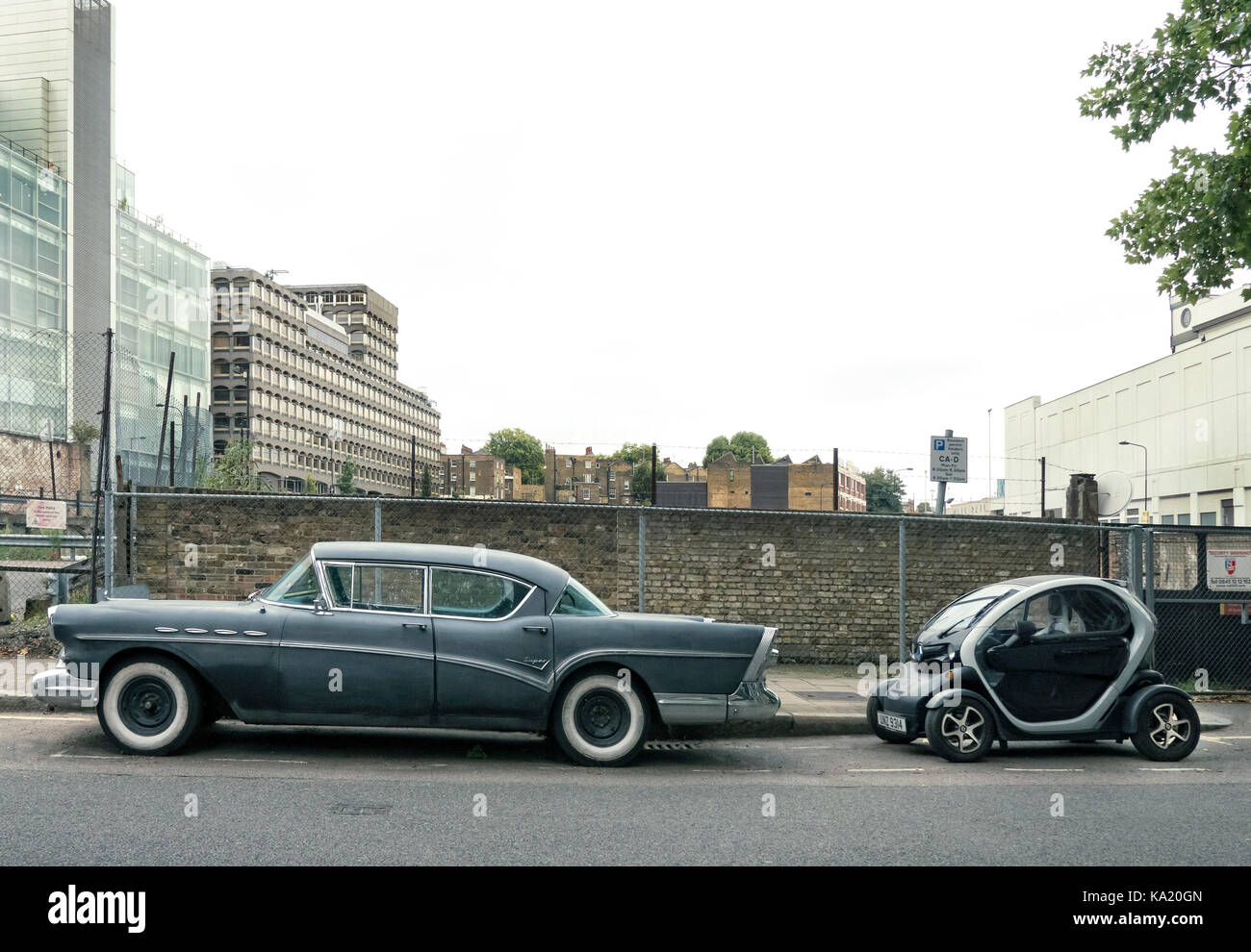 Anni sessanta buick berlina con 2013 renault twizy auto elettriche a Londra. Foto Stock