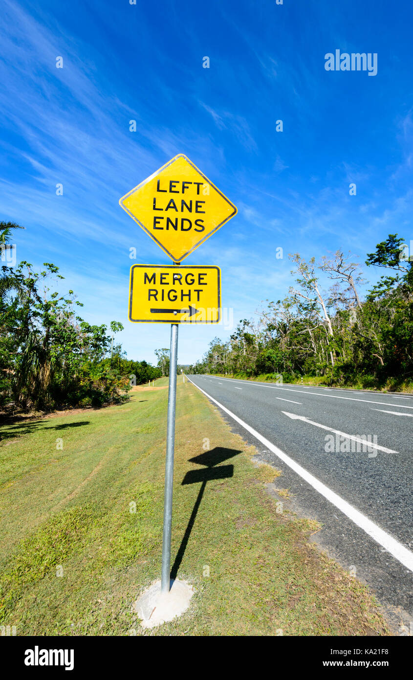 Cartello stradale "corsia di sinistra termina, immettersi a destra', sulla costa di Whitsunday, Queensland, QLD, Australia Foto Stock