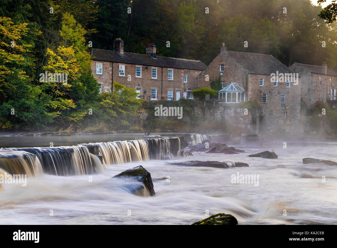 La nebbia che salgono dal Fiume Tees a Mill Falls in Barnard Castle su una fredda mattina autunnale, Teesdale, County Durham, Regno Unito Foto Stock