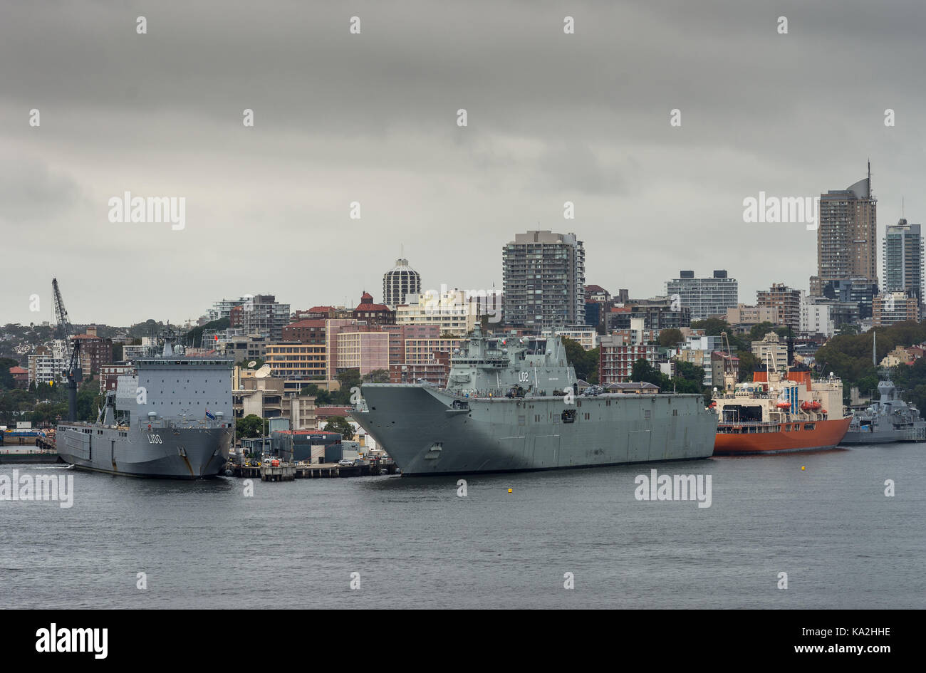 Sydney, Australia - 21 marzo 2017: closeup di diverse navi della marina militare ancorato lungo il giardino isola quays sotto la pioggia, stormy cloudscape e dello skyline della citta'. Foto Stock