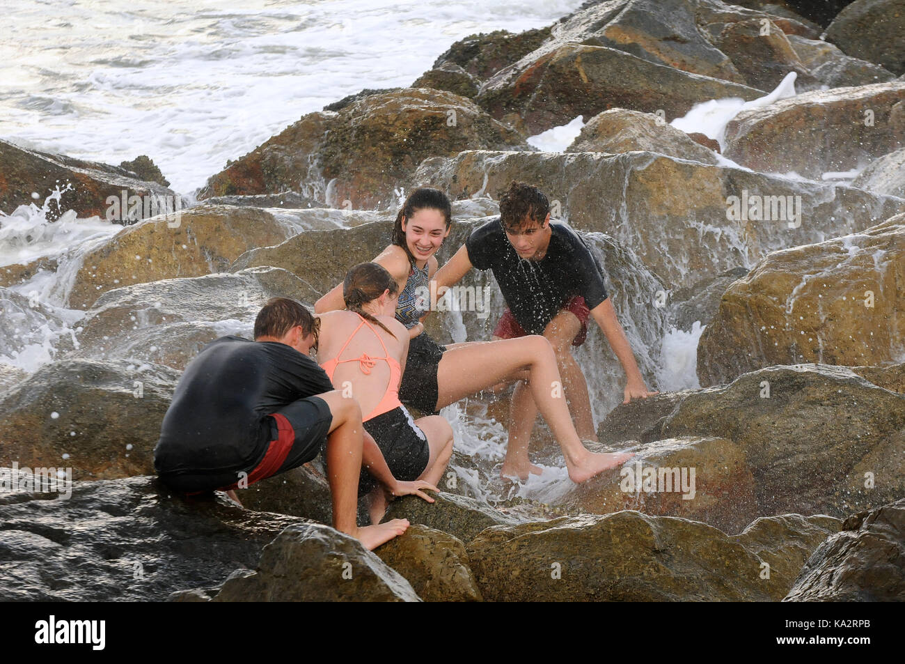 Ponce Inlet, Stati Uniti. 24Sep, 2017. colby savary (l), madelyn Miller, Natalie thomas e David Thomas recuperare dopo essere colpito da surf come onde infrangersi sulle rocce il 24 settembre 2017 in Ponce Inlet, Florida come uragano maria aratri fino alla costa atlantica portando alte onde e correnti di rip dopo aver effettuato un colpo diretto a puerto rico, lasciando tutta l isola senza elettricità. Credito: Paul Hennessy/alamy live news Foto Stock