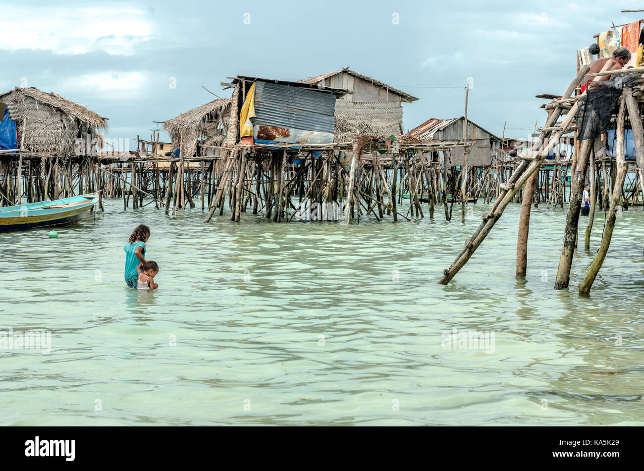 Bambina che porta il suo fratello a casa in Semporna villaggio sul mare, Malaysia Foto Stock