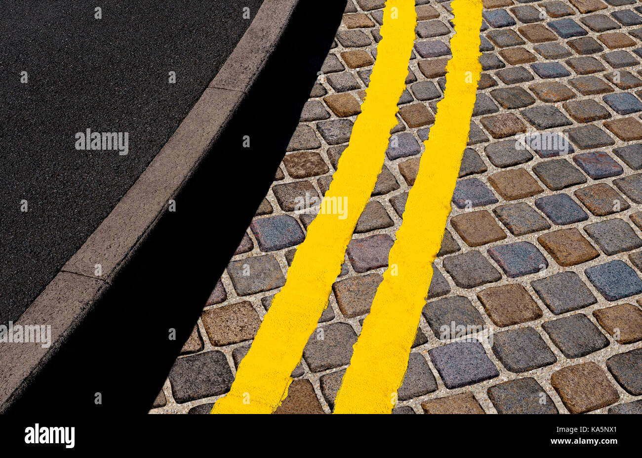 Doppio giallo linee sulla strada di ciottoli Foto Stock