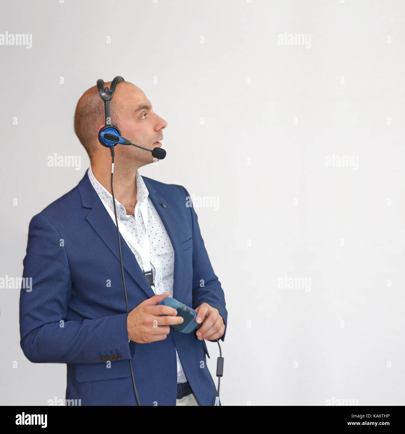 Uomo in tuta blu con tecnologia vocale il dispositivo di elaborazione Foto Stock