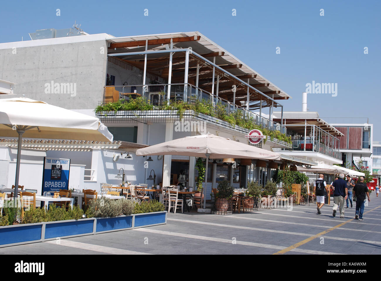 Persone che passeggiano passato ristoranti nel nuovo Marina di Limassol, Cipro Foto Stock