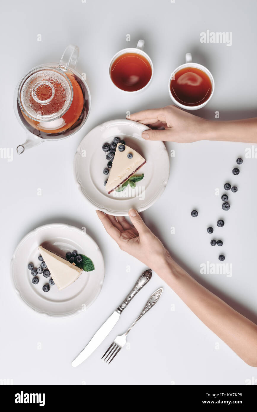 Donna che serve cheesecake con mirtilli sul tavolo Foto Stock Donna che serve cheesecake con mirtilli sul tavolo Foto Stock