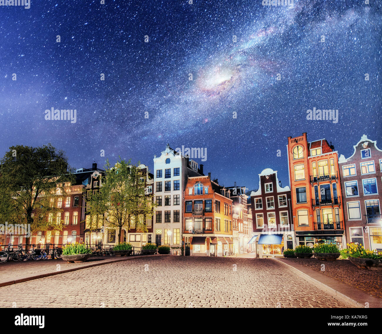 Bella notte a Amsterdam. Illuminazione notturna degli edifici e barche vicino all'acqua nel canale. Foto Stock