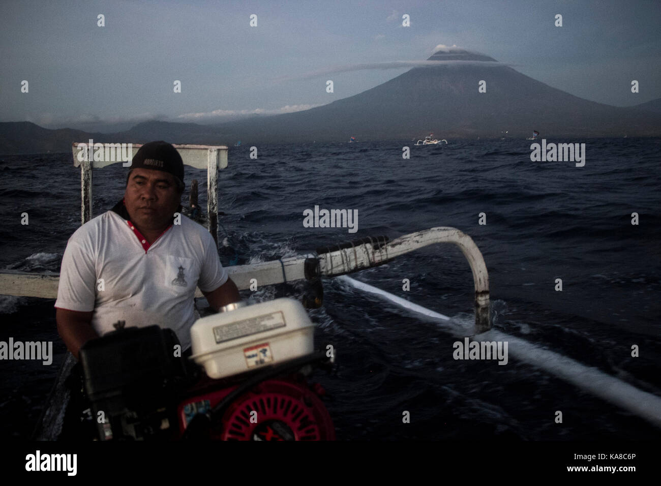 Bali, Indonesia. 26 Sep, 2017. un pescatore con la sua barca è visto vicino il Gunung Agung, o Monte Agung vulcano di amed beach a karangasem regency, Bali, Indonesia. sept. 26, 2017. Il numero degli sfollati è salito a più di 57.000 come Gunung Agung vulcano in bali resort isola è potenzialmente in grado di eruttare, un alto funzionario di agenzia di emergenza detto martedì. Credito: m. fauzi chaniago/xinhua/alamy live news Foto Stock