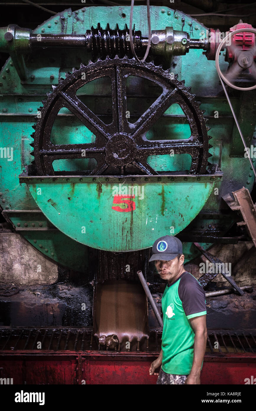 Un operatore di fabbrica di zucchero con macchinari all'interno della fabbrica di zucchero Tasikmadu a Giava Centrale, Indonesia. Foto Stock