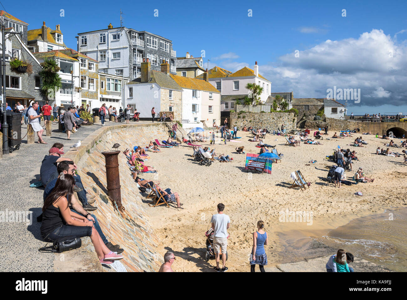 St ives - vacanzieri relax su St ives Harbour Beach di St Ives in Cornovaglia. Foto Stock