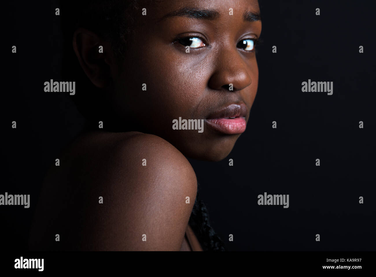 Fiducioso modello femminile su sfondo nero Foto Stock
