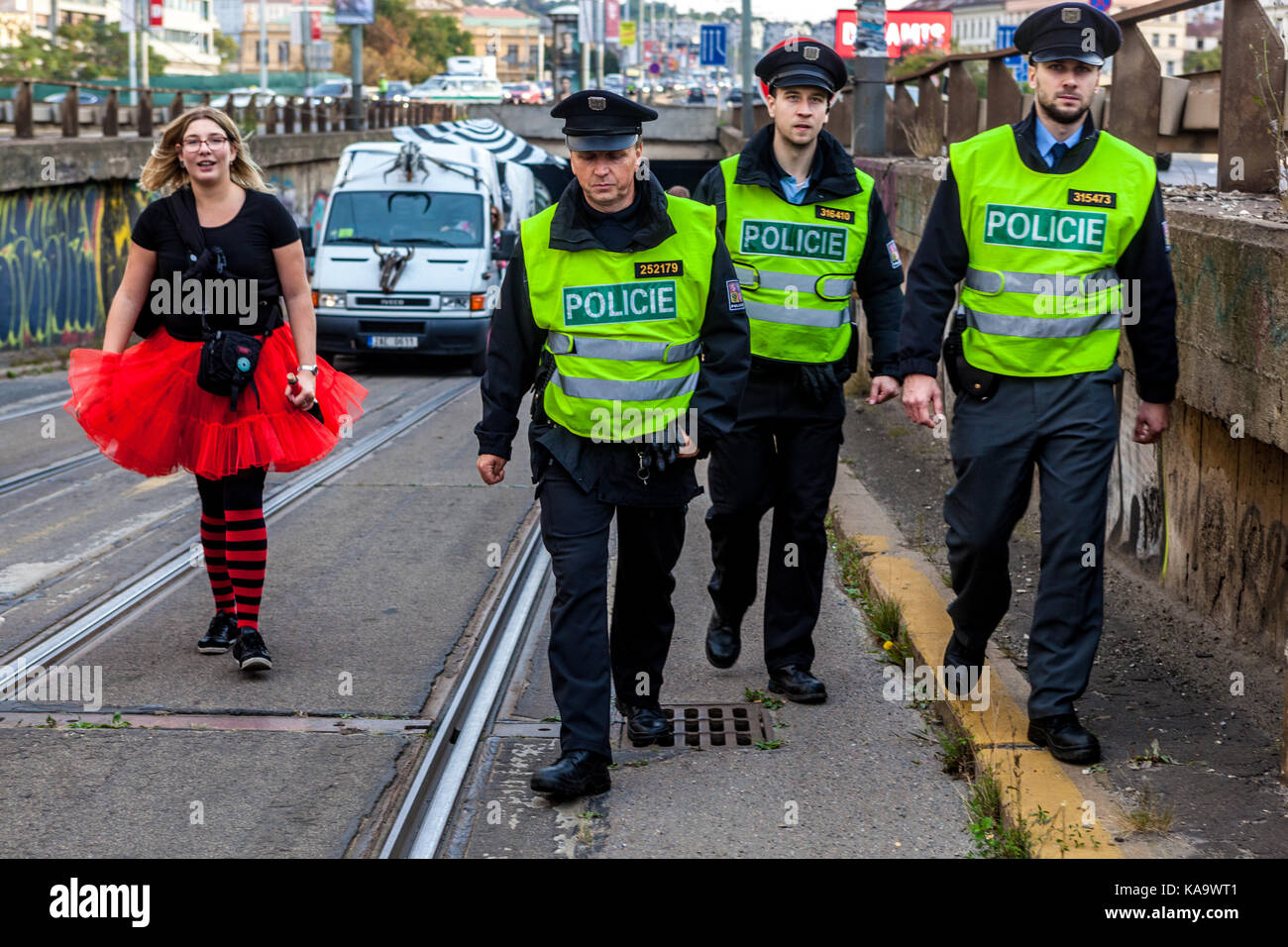 La polizia ceca. Tre poliziotti, sullo sfondo di una donna in gonna rossa, Praga, Repubblica Ceca Foto Stock