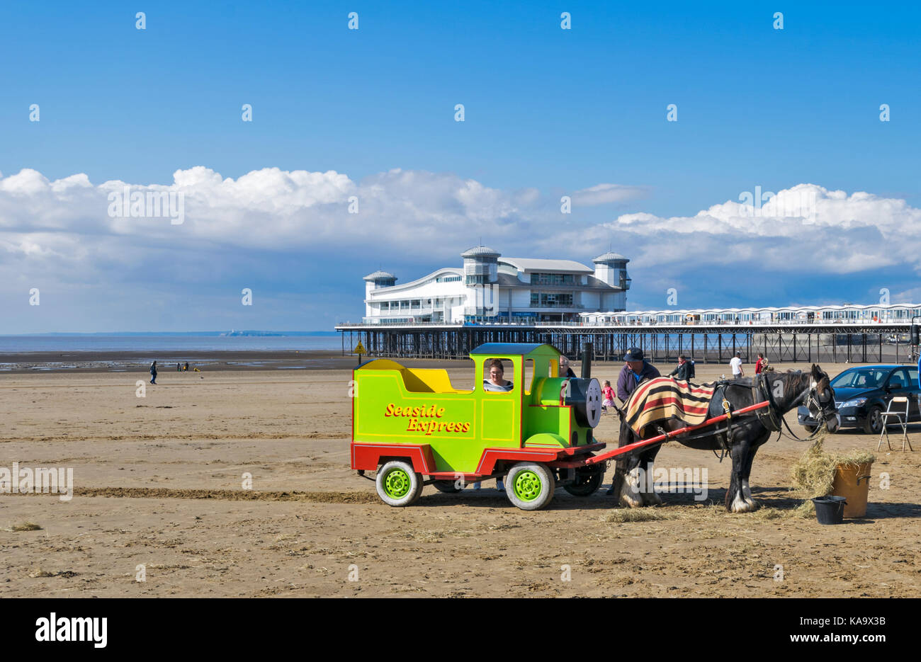 WESTON SUPER MARE SOMERSET Inghilterra una giornata soleggiata con cavallo e il carrello scorre su una spiaggia di sabbia e il GRAND PIER A BASSA MAREA Foto Stock