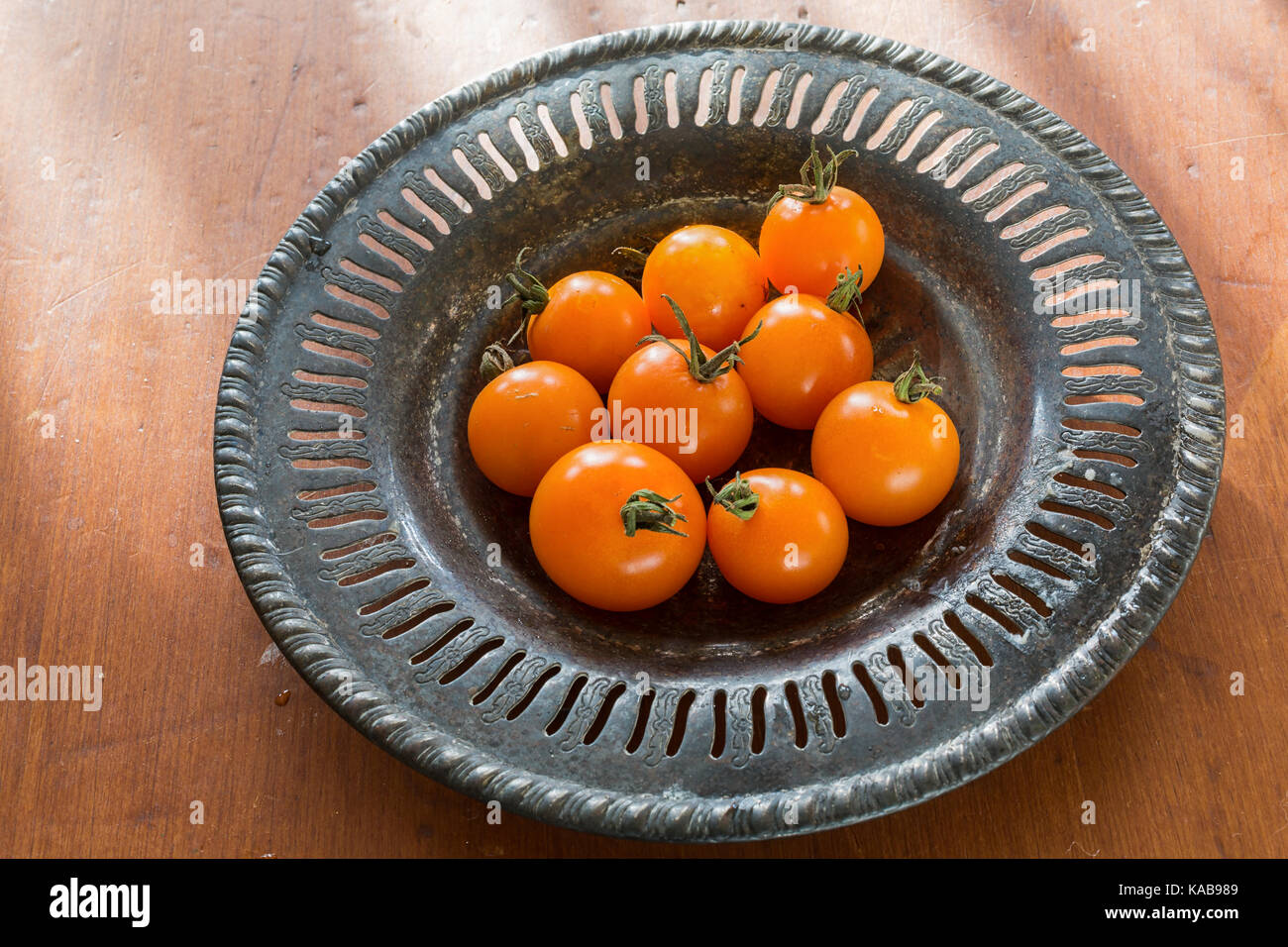 Pomodori in miniatura su un raffinato peltro piastra. Foto Stock