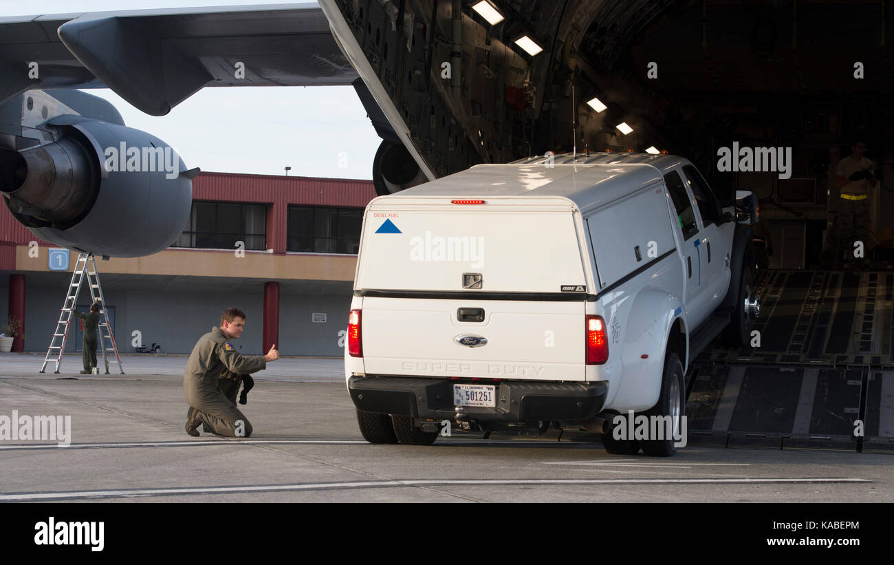 Airman 1. Classe Logan Smith, 3d Airlift Squadron loadmaster, martials una Ford F-450 pickup truck come si ritira un C-17 Globemaster III, Sett. 24 Foto Stock