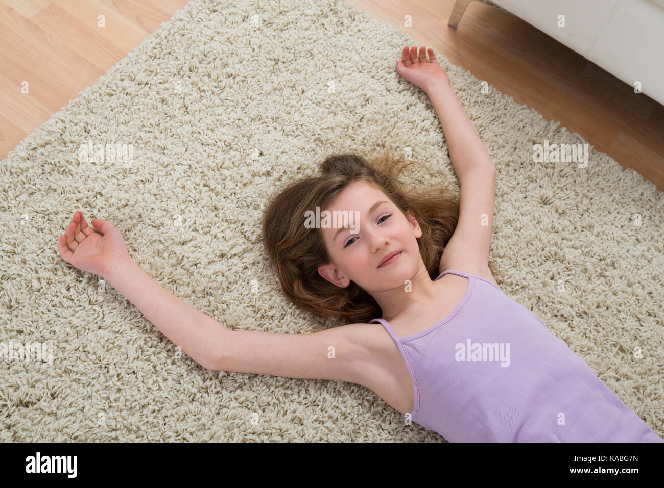 Angolo di alta vista della ragazza in appoggio sul tappeto dopo allenamento a casa Foto Stock