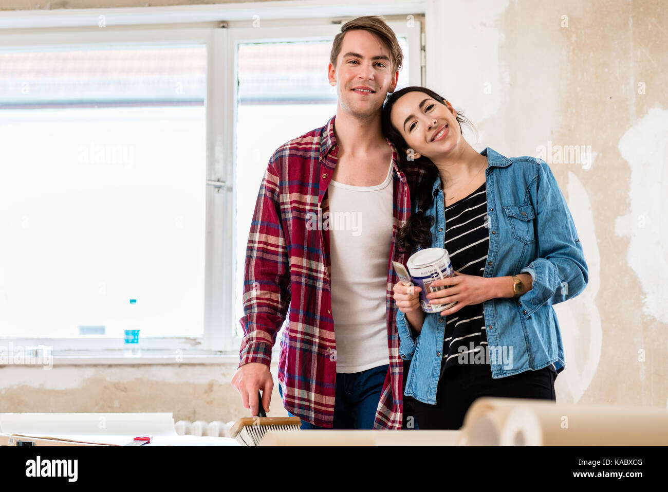 Ritratto di una felice coppia giovane azienda gli strumenti per home remodeli Foto Stock