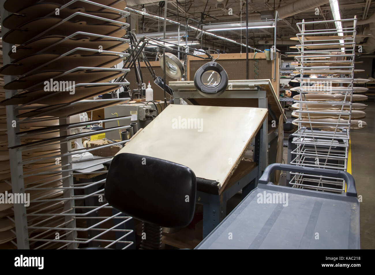 Redazione tavolo circondato da modelli in legno nella fabbrica di strumenti musicali. Foto Stock